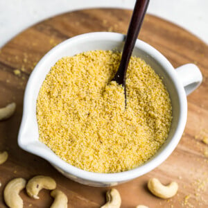 Learn how to make your own vegan parmesan cheese at home. It requires just 4 ingredients and only about 5 minutes of your time! Trust us, this recipe is a MUST TRY! #vegan #cheese #4ingredient #5minute #staple #vegancheese #kids #musttry #side #snack #entree #italian #parmesan #sweetsimplevegan