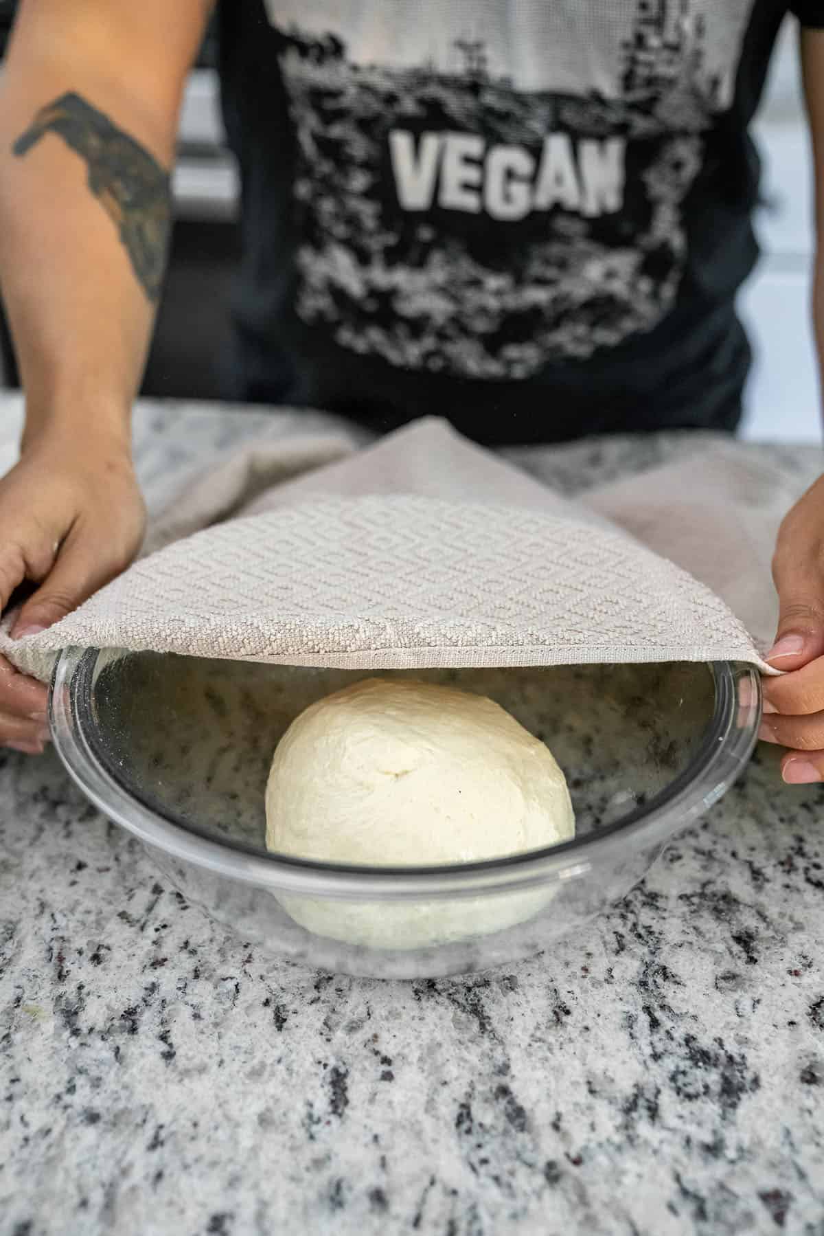 putting pizza dough in oiled bowl to rise