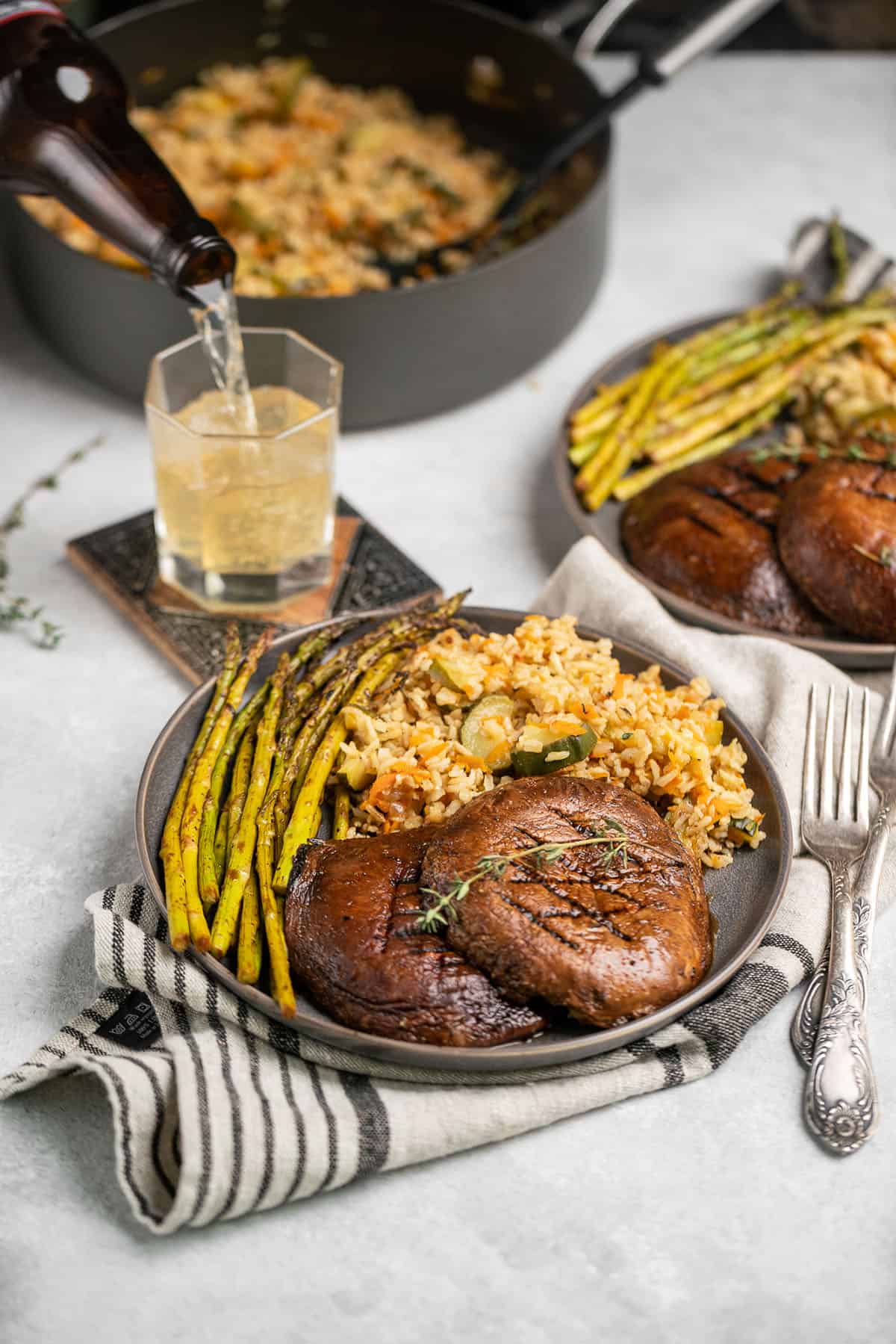 mushroom steak on gray plate with rice pilaf and asparagus