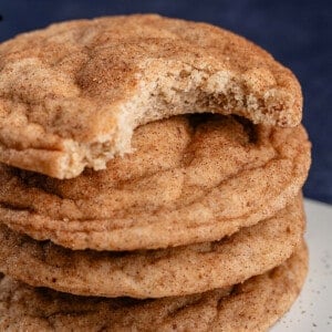 stack of classic vegan snickerdoodles with the top cookie has a bite taken out