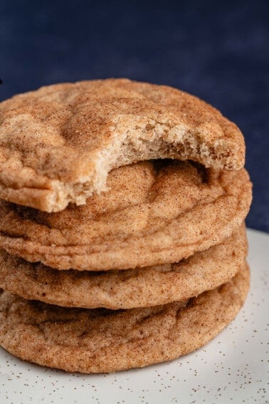 stack of classic vegan snickerdoodles with the top cookie has a bite taken out