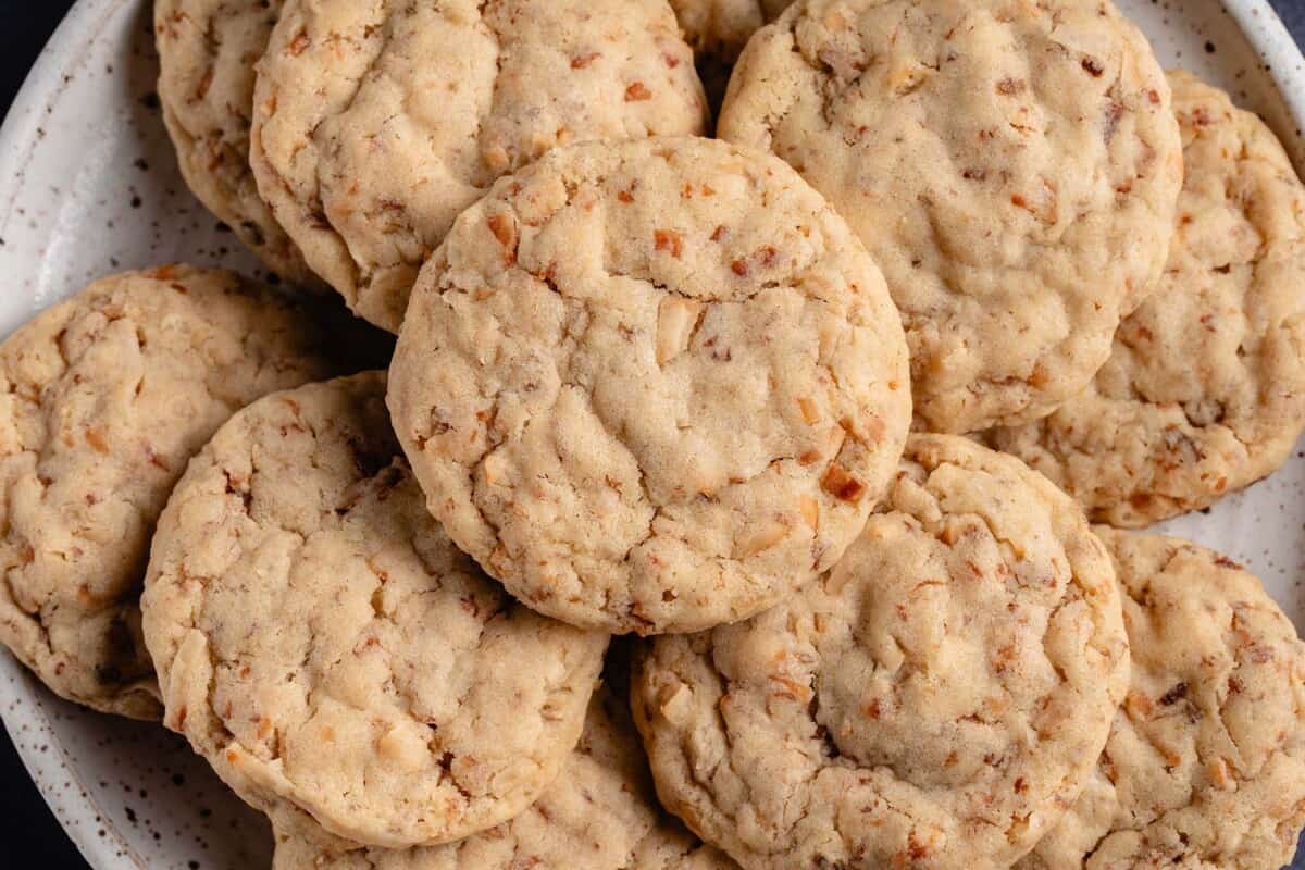 horizontal photo close up of toasted coconut sugar cookies on white plate