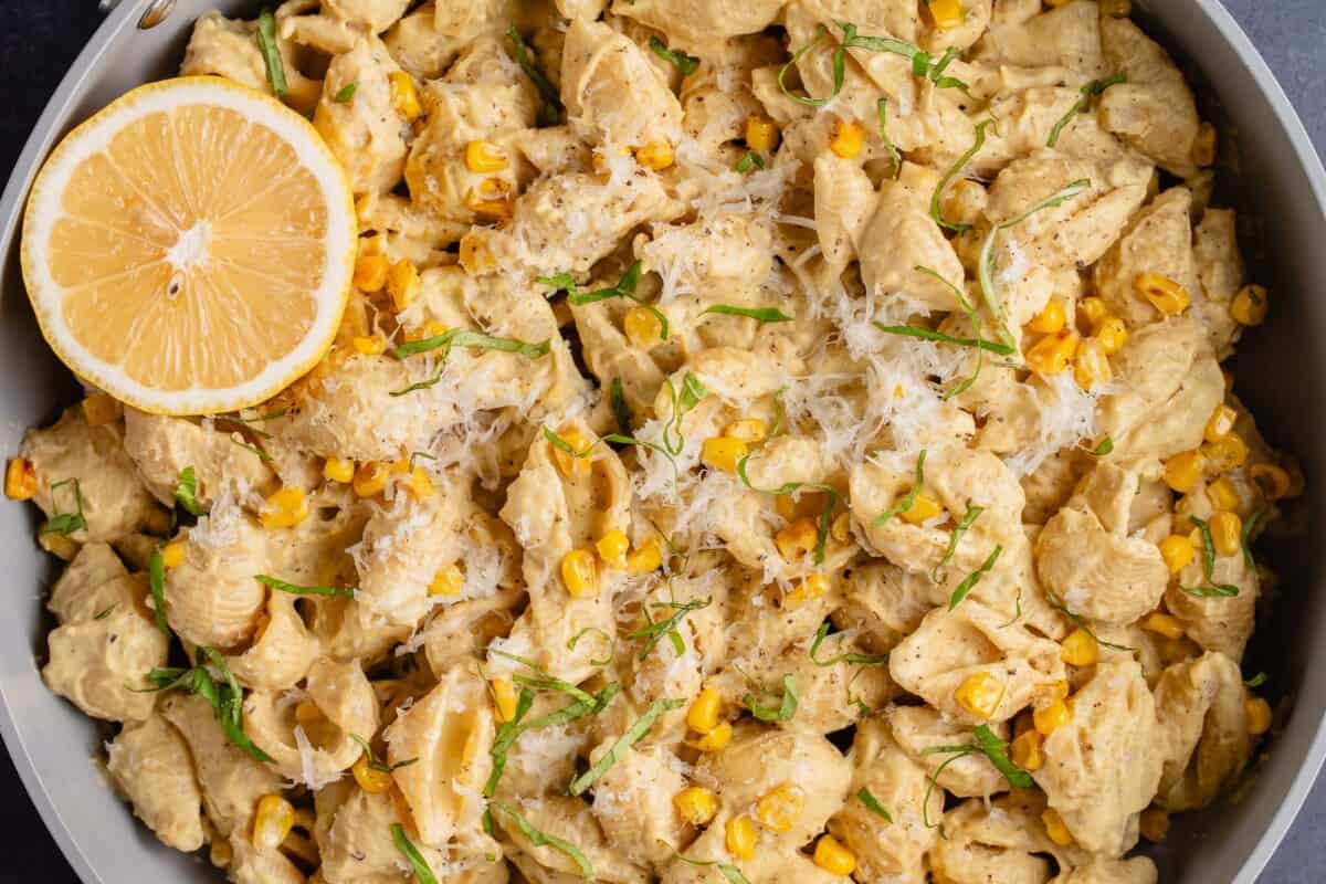 horizontal image of creamy corn pasta in a pan