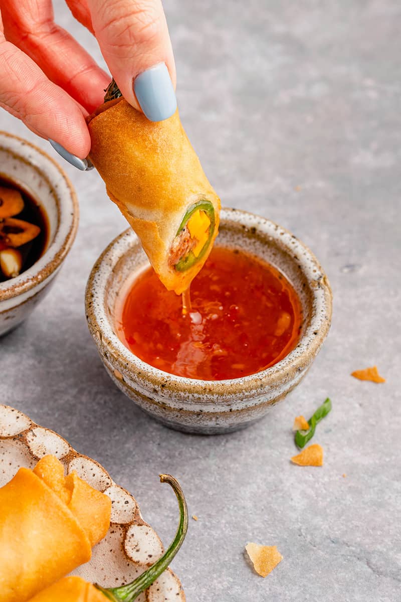 dipping dynamite lumpia in sweet chili sauce