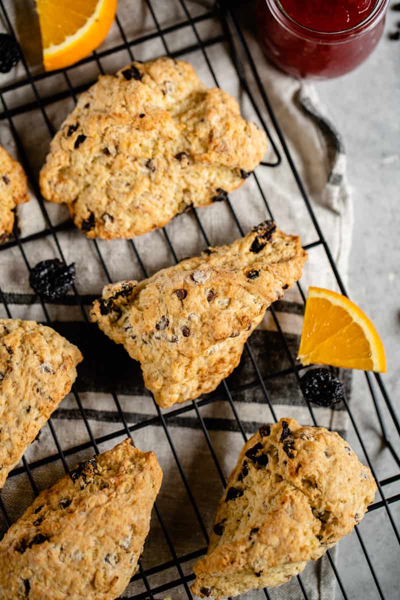 dried chocolate cherry scones on cooling rack with orange pieces