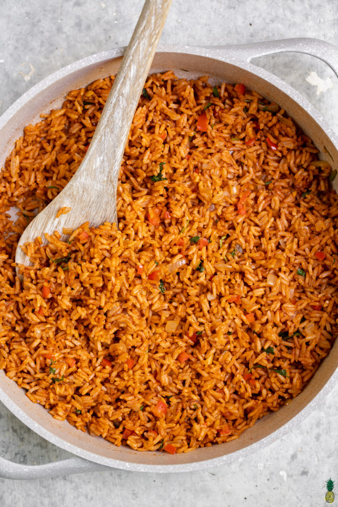 Close up shot of Spanish Rice in a white pan with a serving spoon
