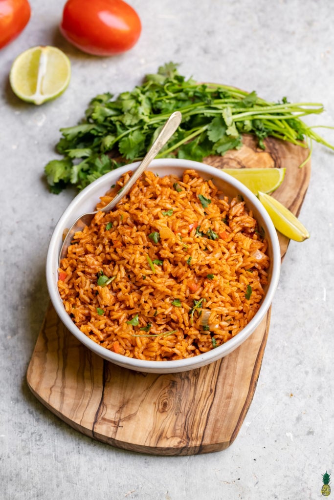 Homemade Spanish Rice in a white bowl with a serving spoon