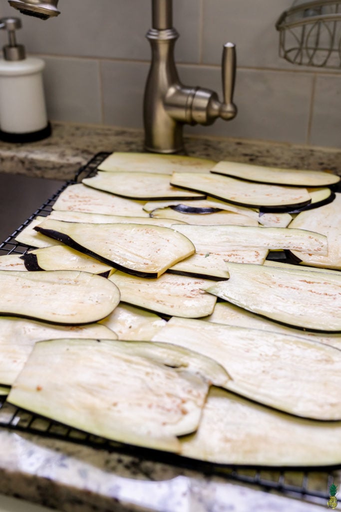 sweating raw eggplant lightly salted laying out over the sink
