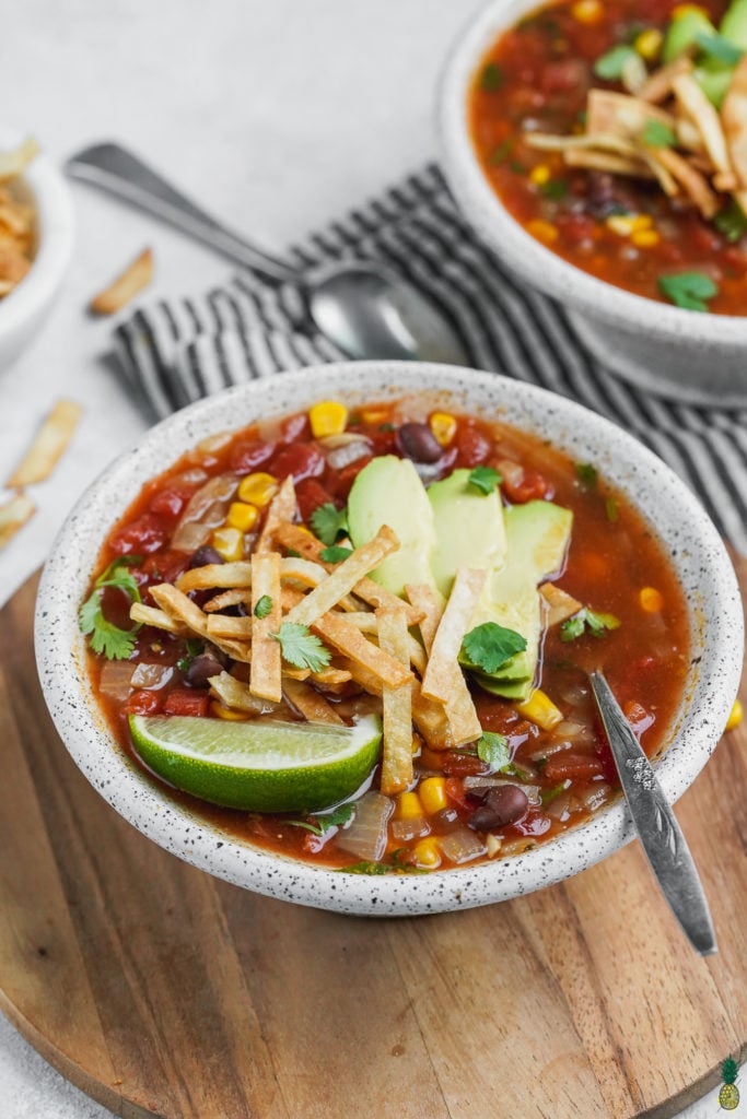 A bowl of soup with garnishes and a spoon