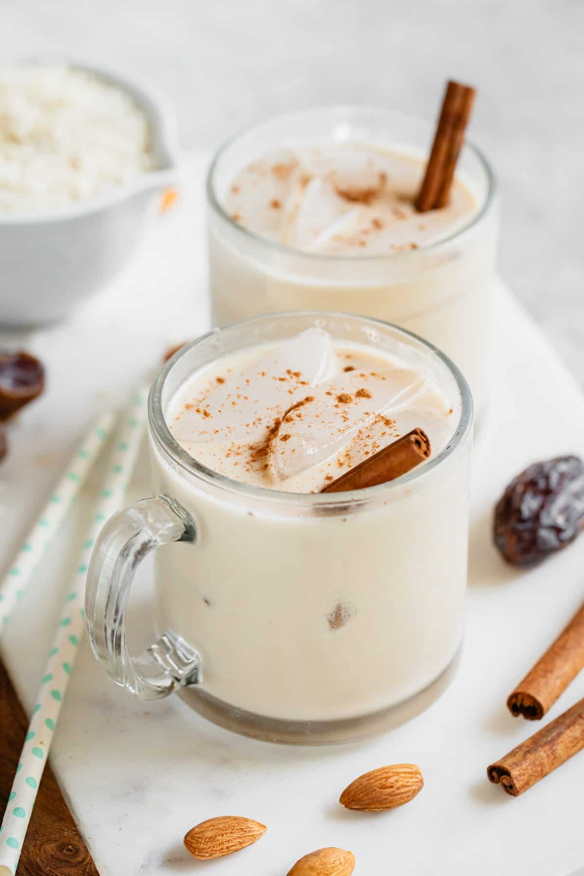 glass cups with date sweetened horchata and cinnamon sticks