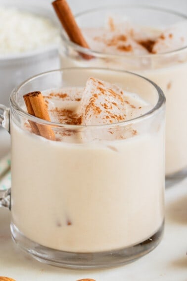 glass cups with date sweetened horchata and cinnamon sticks