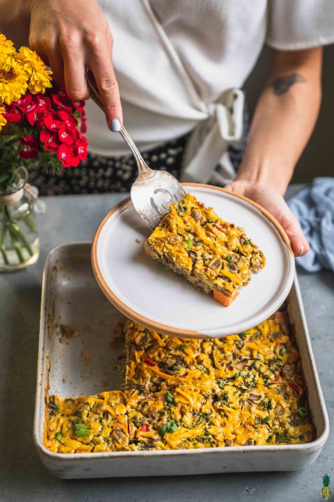 Serving shot of a vegan sweet potato breakfast casserole in a white dish by sweet simple vegan