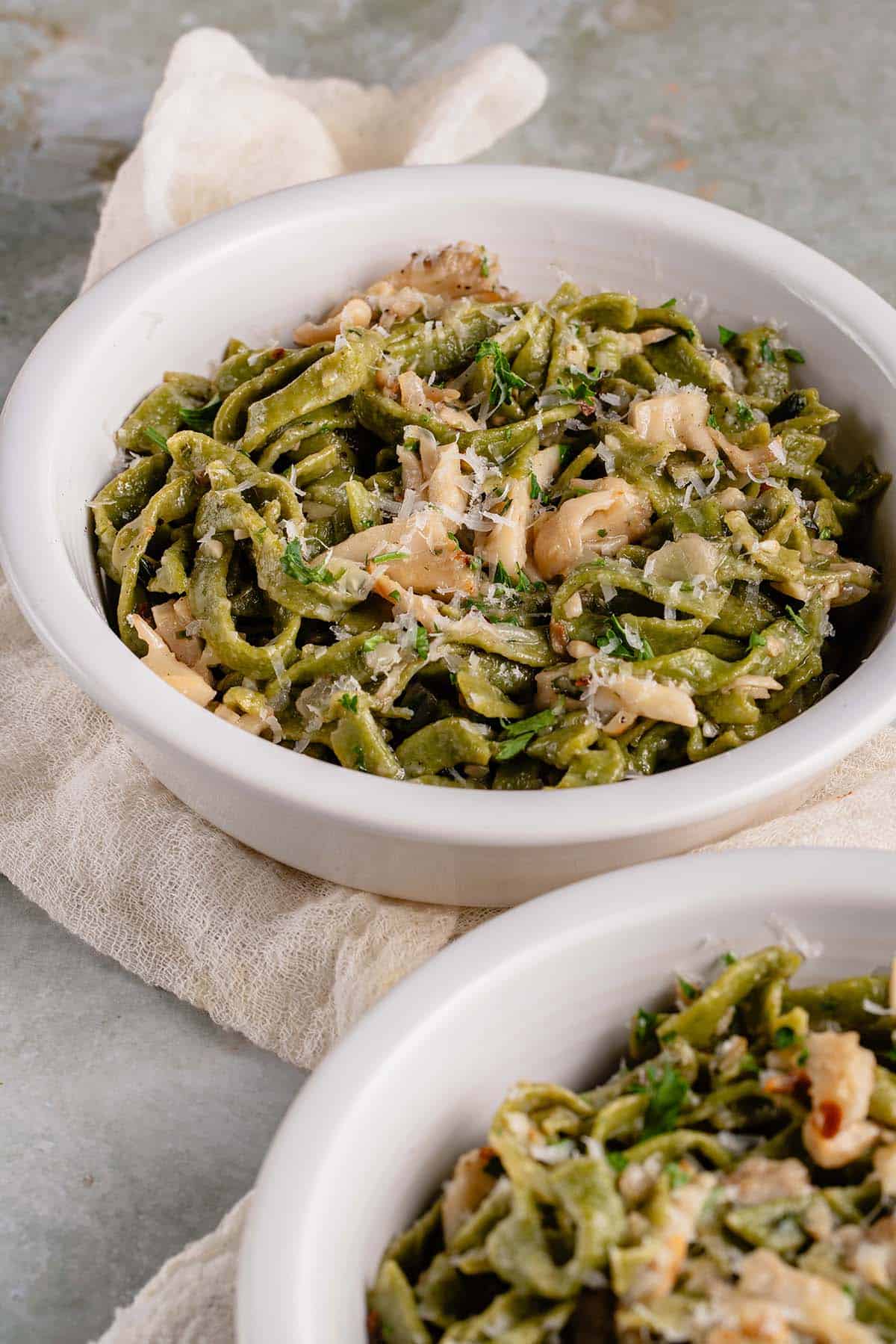 fresh spinach pasta in white bowl with mushroom butter sauce
