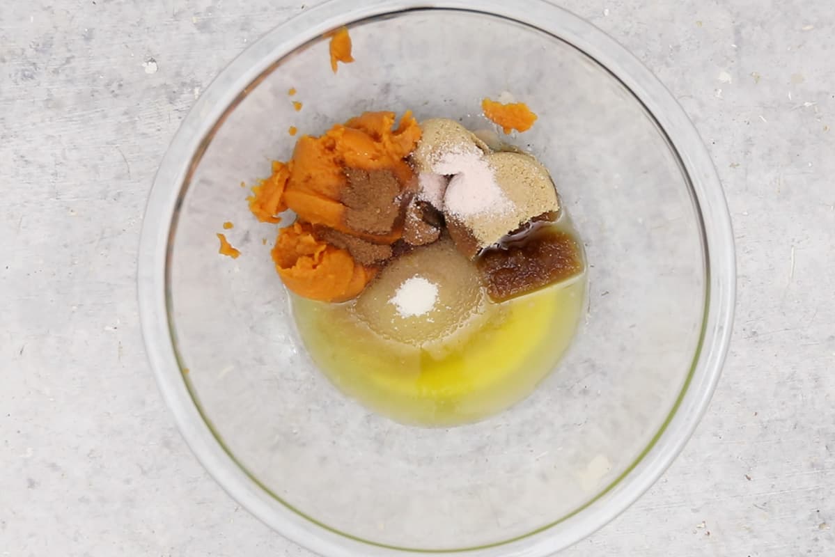 mixing wet ingredients for pumpkin chocolate chip cookies in glass bowl