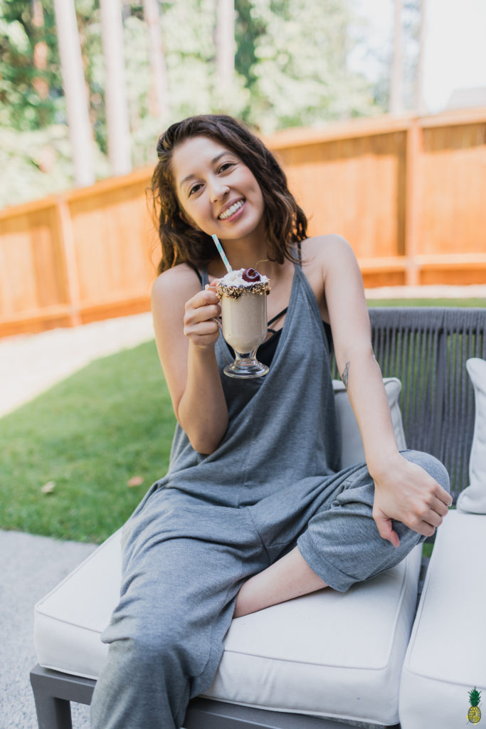 Jasmine Sweet Simple Vegan holding a vegan date shake milkshake 