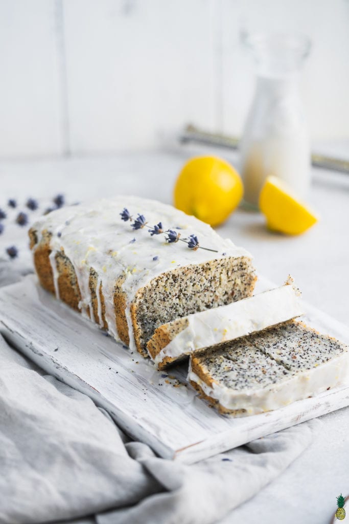 Gluten-free vegan lemon poppyseed loaf with a glaze slices on a cutting board is a delicious spring dessert. 