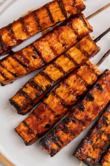 overhead photo of grilled barbecue tofu skewers on plate