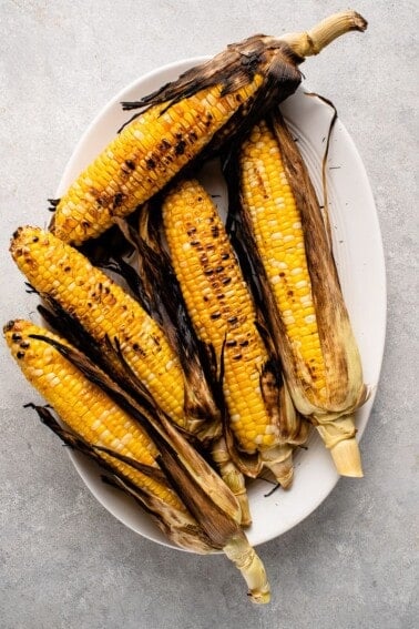 grilled corn on a white serving platter