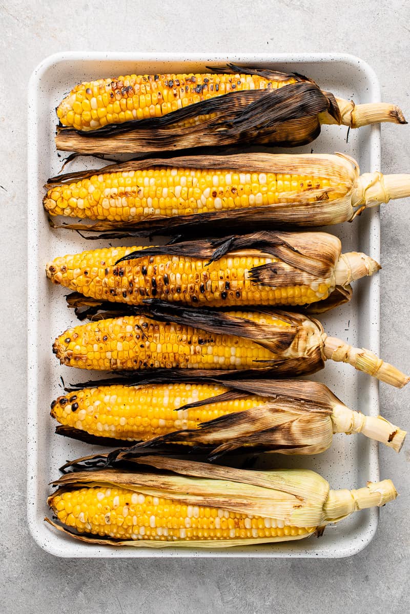 grilled corn on a white baking dish
