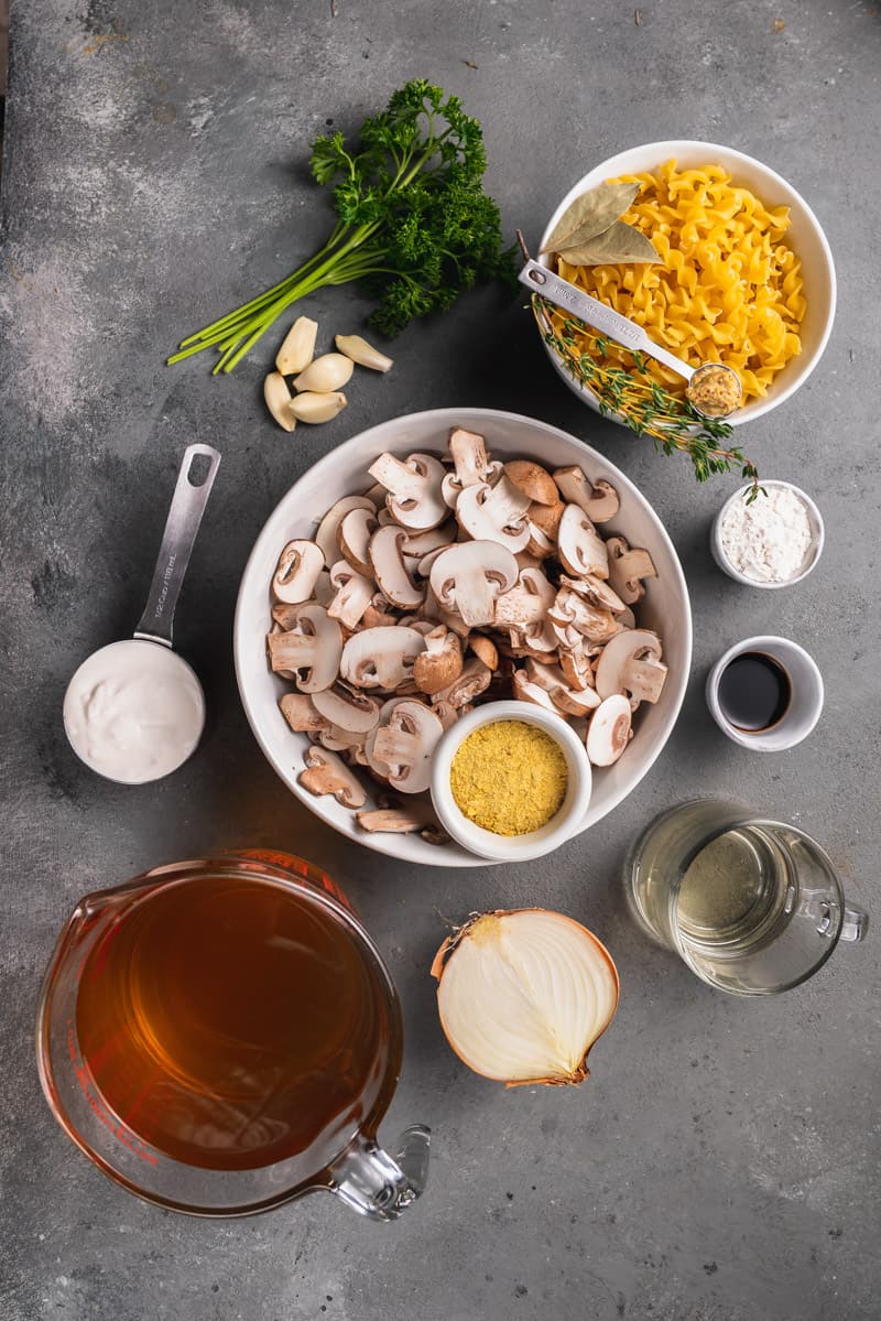 overhead image of mushroom stroganoff ingredients on grey background