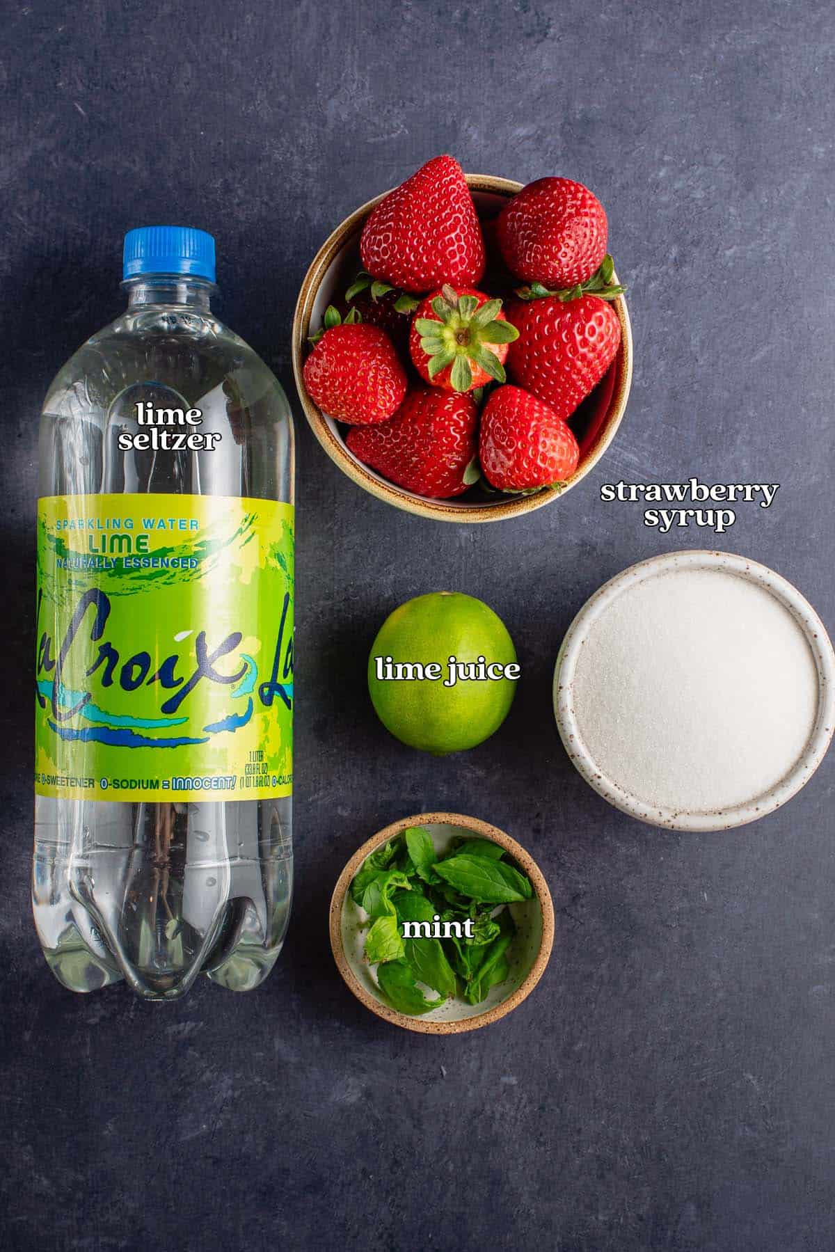 ingredients for strawberry mojito on blue board