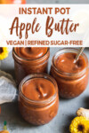 three jars filled with homemade apple butter surrounded by flowers apples and lemon by sweet simple vegan for pinterest