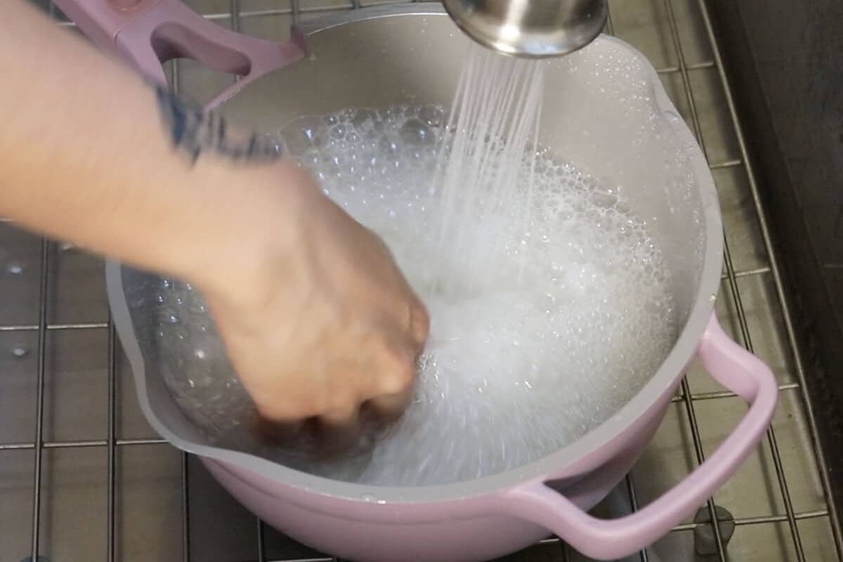 rinsing sweet rice in purple pot