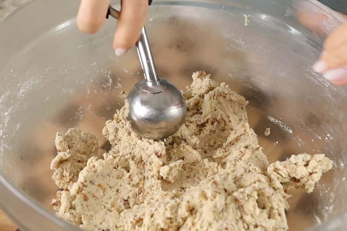 scooping coconut sugar cookie dough in glass bowl