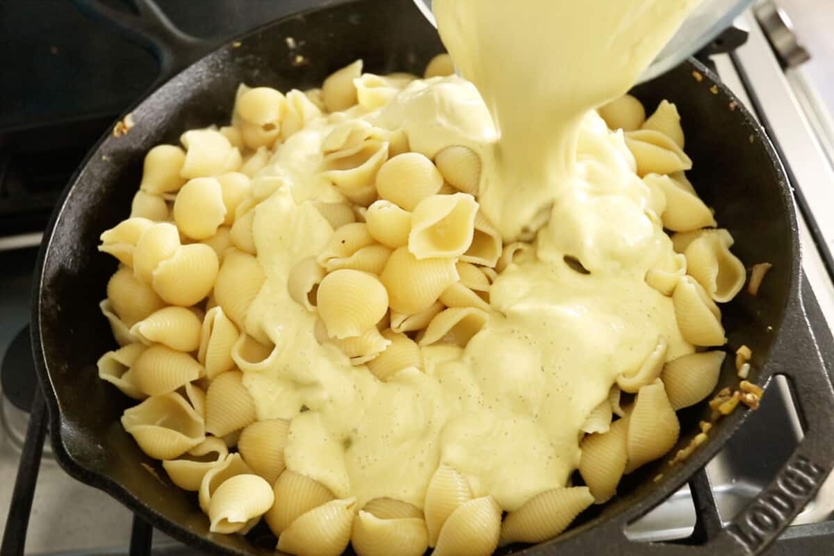 step by step sauce being poured over shell pasta