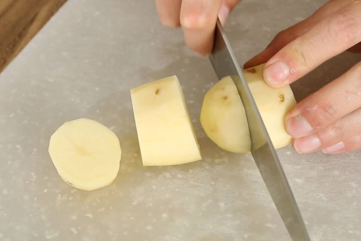 slicing peeled russet potatoes