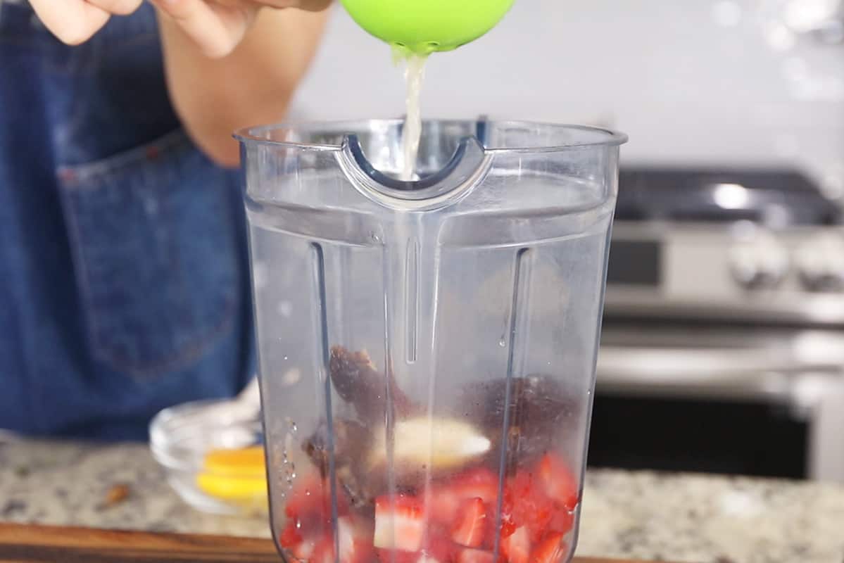 adding fresh lemon juice to vitamix blender for strawberry lemonade