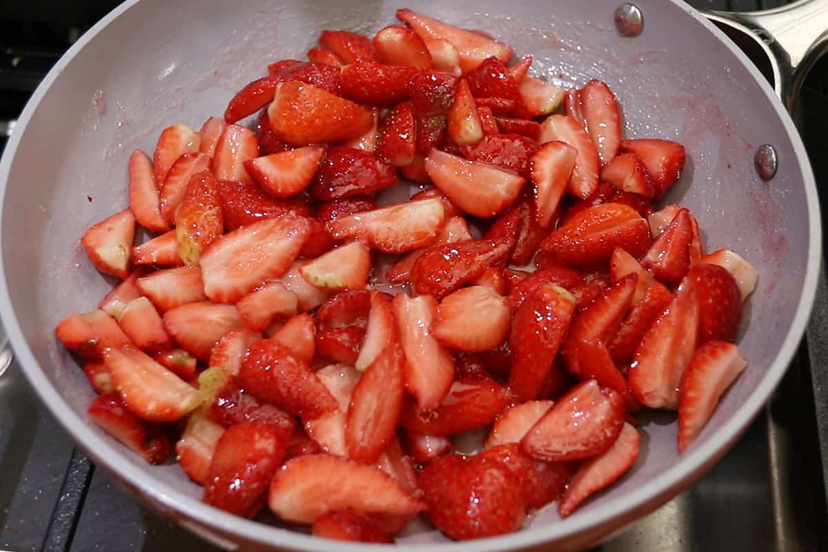making a sweet strawberry topping for cheesecake in caraway non-stick pan