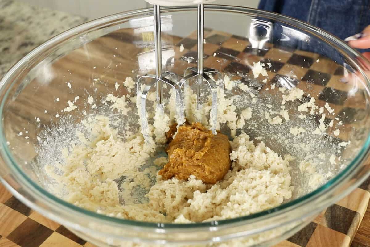 spiced pumpkin puree being creamed in with butter and sugar