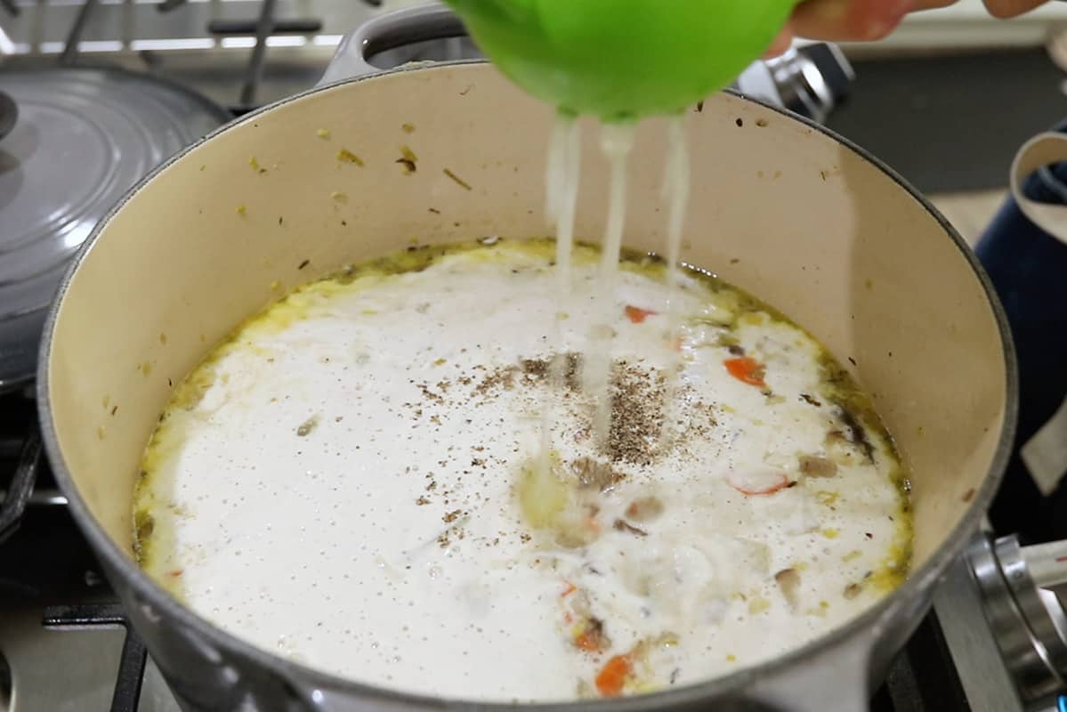 adding lemon juice to large pot of vegan clam chowder
