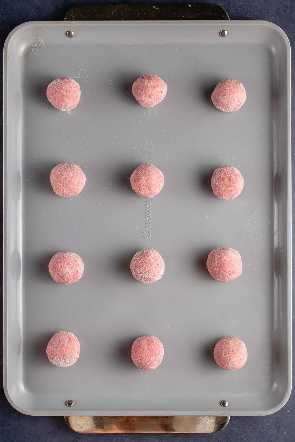 strawberry sugar cookie dough balls on nonstick caraway baking sheet