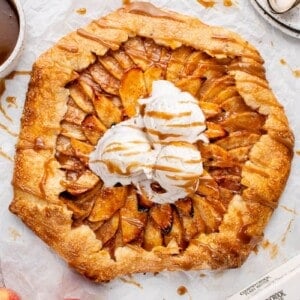 vegan apple galette with vanilla ice cream and caramel sauce on a white board