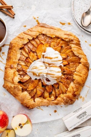 vegan apple galette with vanilla ice cream and caramel sauce on a white board