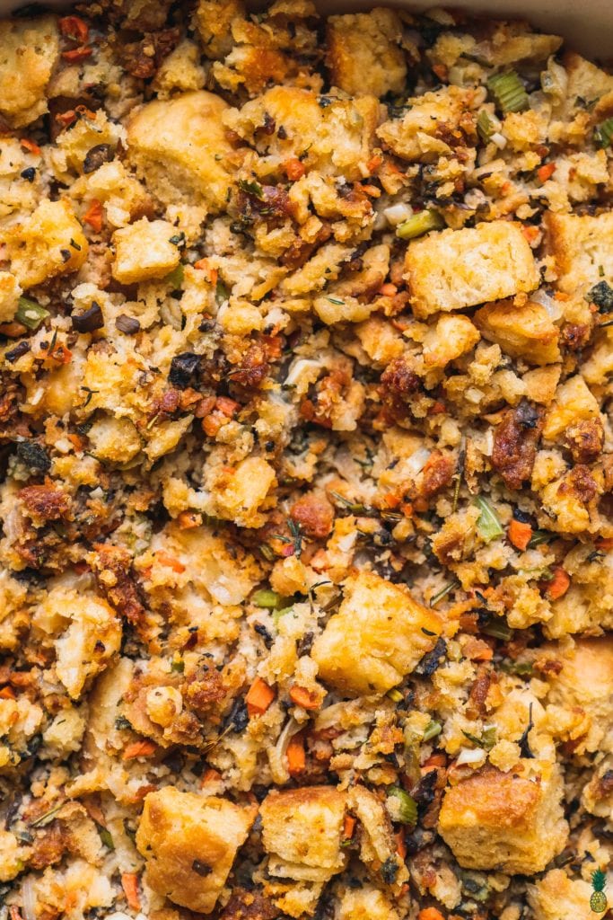 Closeup shot of a buttermilk biscuit thanjsgiving stuffing with vegetables and herbs by sweetsimplevegan