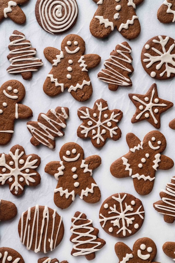 an overhead shot of gingerbread cookies with white icing on a marble background