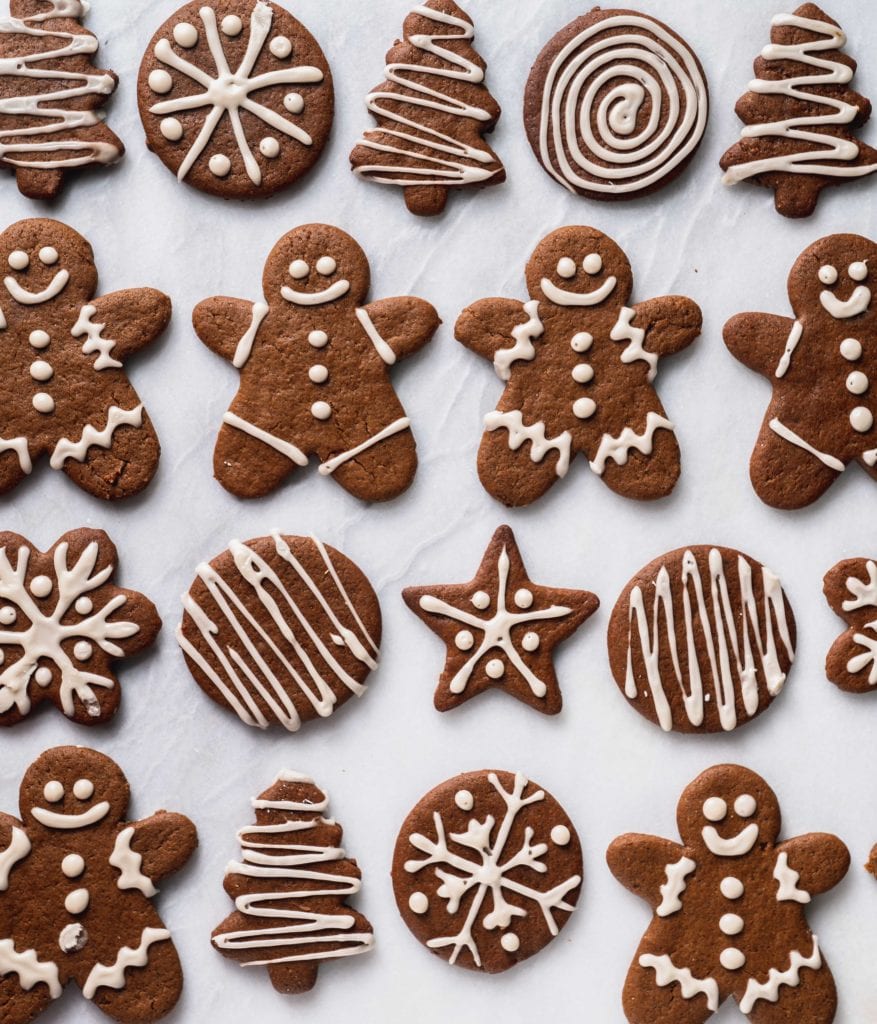 an overhead shot of gingerbread cookies with white icing on a marble background