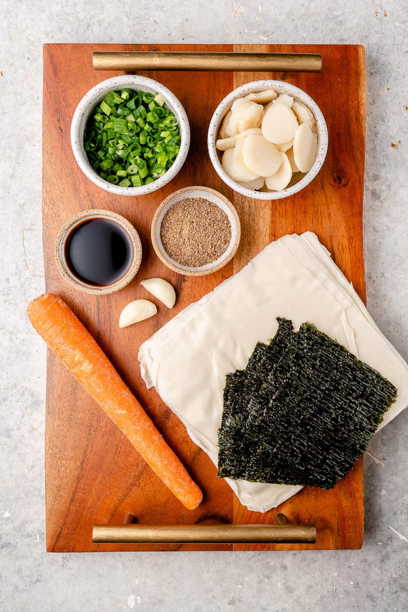 overhead image of ingredients for lumpiang shanghai (vegan spring rolls) on wooden tray by sweet simple vegan