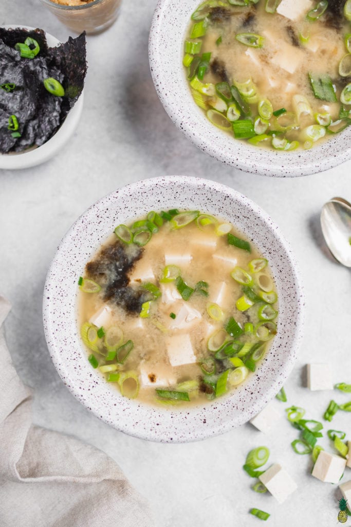 Miso soup with tofu in white bowls, vegan, close up