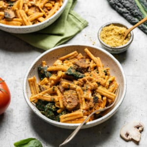 Gluten free pasta with roasted red pepper and tomato sauce in a ceramic bowl; food photograph by sweet simple vegan