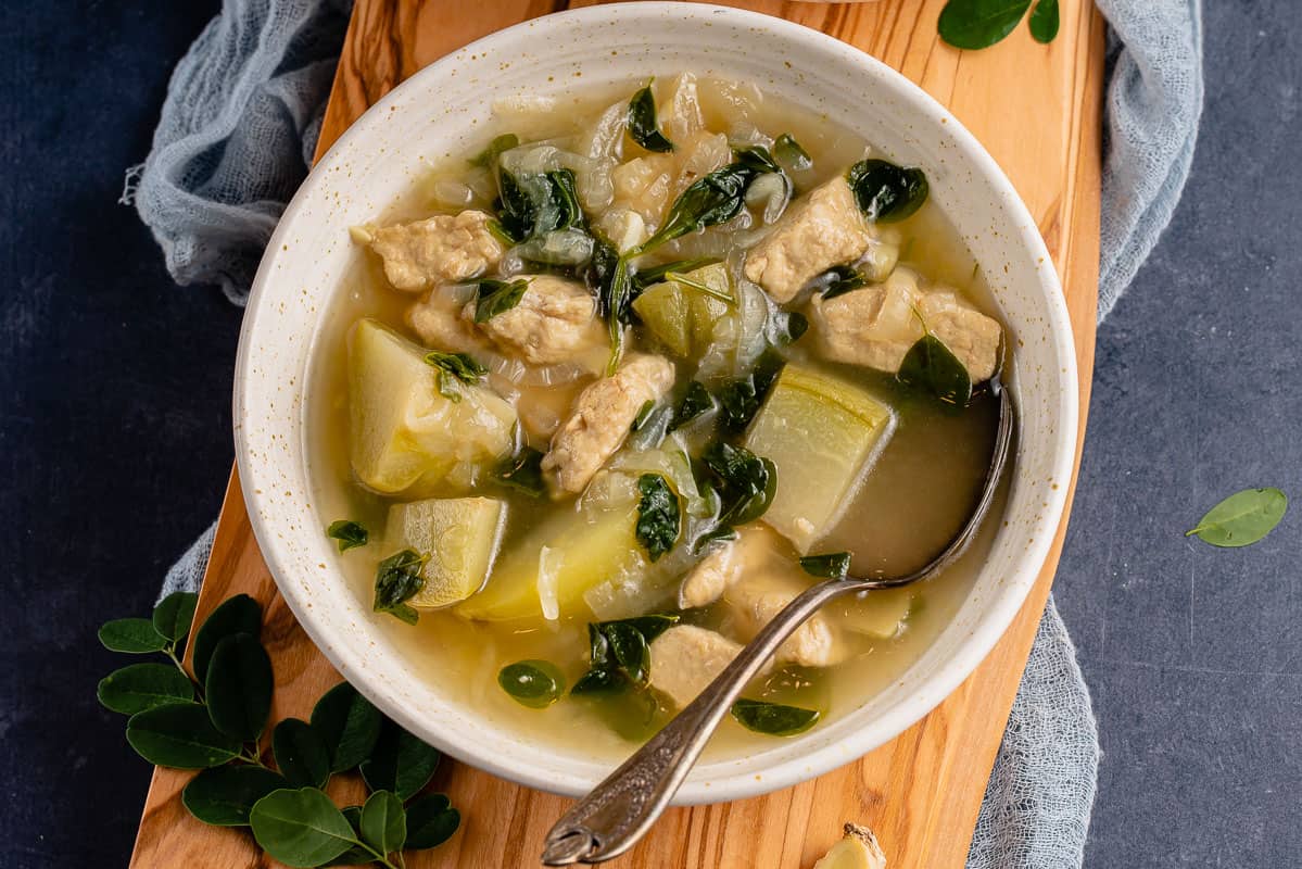 bowl of tinolang manok on styled background with spoon