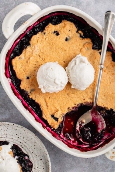blueberry cobbler in white baking dish with ice cream