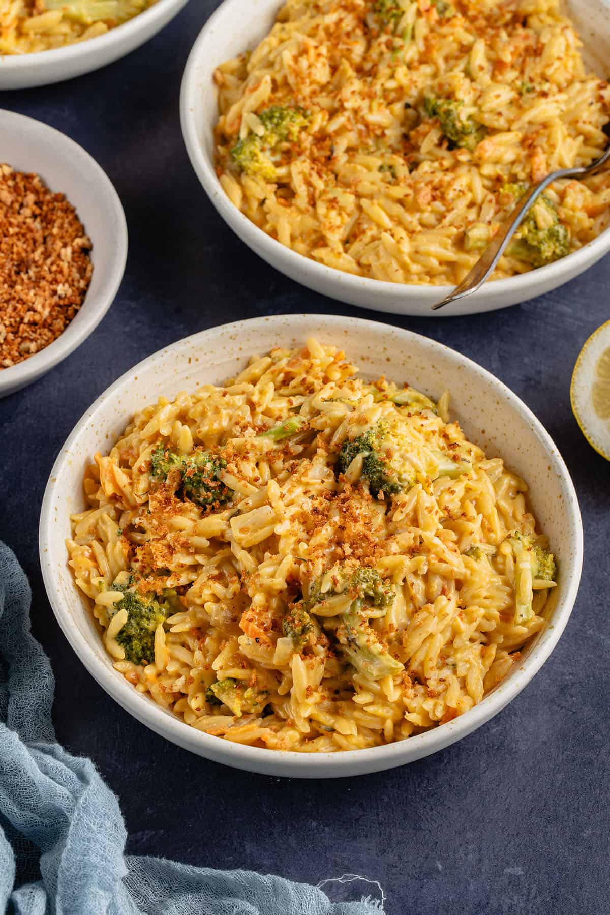 broccoli cheddar orzo with breadcrumbs in beige bowl