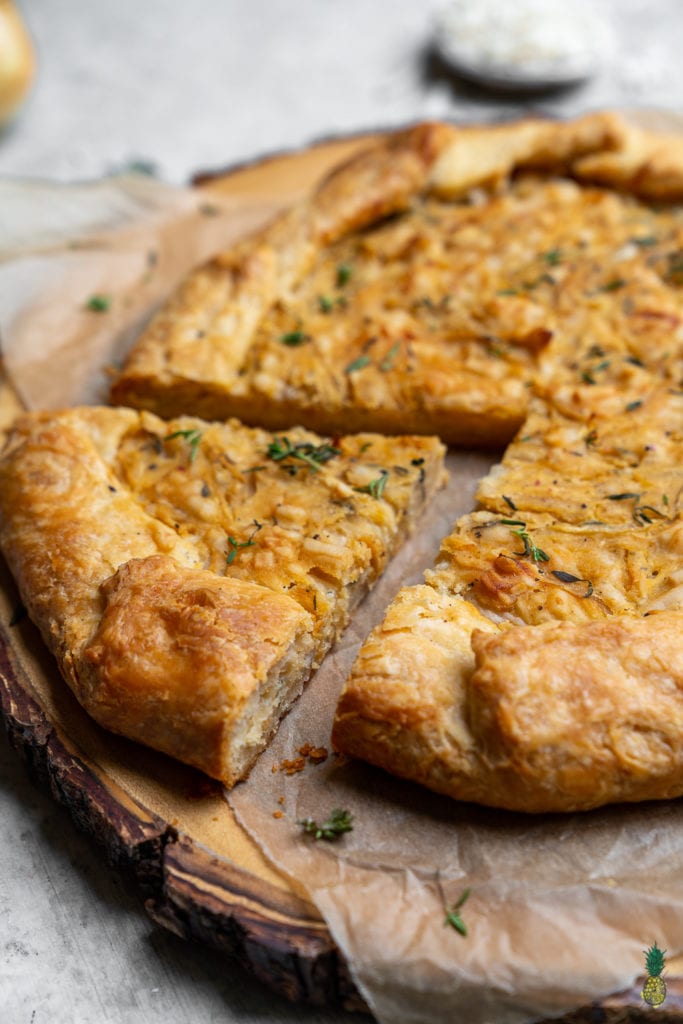 Caramelized onions paired with thyme and vegan cheese, all wrapped in a flaky homemade tart crust. Need I say more? This tart is perfect for entertaining guests and will be the hit of any party! #vegan #onion #tart #savorytart #side #appetizer #party #musttry #easy #veganpastry #veganized #bestofvegan #sweetsimplevegan #caramelized