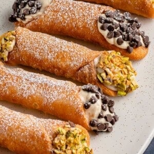 vertical photo of Vegan Cannoli with Chocolate and Pistachios on white plate