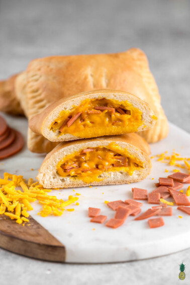 A veganized version of a popular frozen dish, minus all the weird stuff. You really only need THREE ingredients for this recipe—store-bought dough, vegan ham and vegan cheddar cheese. These are perfect for school or work, kids will love them AND they will take you right back to your childhood. #vegan #hotpockets #homemade #healthier #easy #3ingredients #fooldproof #kids #vegankids #veganschool #veganlunchbox #workmeal #lunchbox #childhood